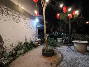 a courtyard with a tree and a wall with lights at Leisure Corner 17 茶馆民宿 in Bukit Mertajam
