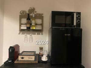 a kitchen with a microwave and a black refrigerator at B&B Vicolo dei Sartori in Salerno