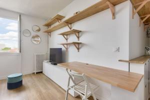 Cette chambre dispose d'une table en bois et d'un bureau. dans l'établissement Splendide studio au cœur du 15e arr, à Paris