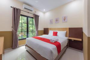 a bedroom with a large bed and a window at RedDoorz Plus @ La Asiana Guest House in Kanggraksan