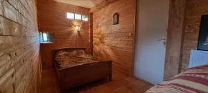 Habitación con pared de madera y banco. en Le Pradima en Mandailles