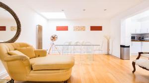 een woonkamer met een stoel en een tafel bij Notting Hill Luxury 3BR Duplex Modern Spacious Gem in Londen