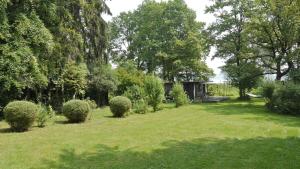 a garden with a bench and some bushes and trees at Hotel Maurerhansl in Dießen am Ammersee