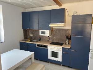 a kitchen with blue cabinets and a white stove top oven at Zimmervermietung Graupner in Rossau