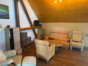 een woonkamer met een bank en een tafel en stoelen bij Zimmervermietung Graupner in Rossau
