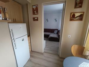 a kitchen with a refrigerator and a living room with a couch at Rahu34 in Jõhvi