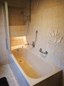 La salle de bains est pourvue d'une baignoire et d'une douche. dans l'établissement 65 qm Ferienwohnung im Sauerland, à Finnentrop