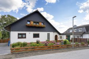 une maison blanche avec un toit noir dans l'établissement 65 qm Ferienwohnung im Sauerland, à Finnentrop