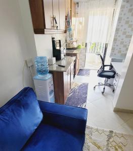 a living room with a blue couch and a kitchen at Newly Furnished 1-bedroom in Nairobi