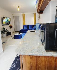 a kitchen and living room with a blue couch at Newly Furnished 1-bedroom in Nairobi +6 photos