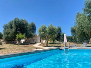 a swimming pool with an umbrella and an umbrella at Trullo Cinderella mit Mountainbike & Pool in Martina Franca