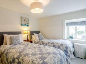 a bedroom with two beds and a window at 3 Bed in Helmsley 82891 in Helmsley