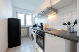a kitchen with a refrigerator and a washer and dryer at SU02 Work & Stay in Groß-Gerau! in Groß-Gerau