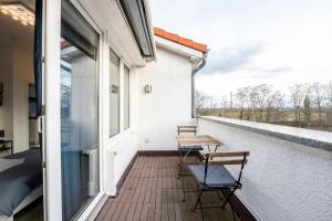 een balkon met 2 tafels en stoelen in een gebouw bij SU02 Work & Stay in Groß-Gerau! in Groß-Gerau