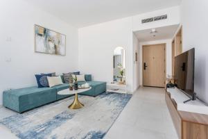 un soggiorno con divano blu e TV di Frank Porter - Marquise Square Tower a Dubai