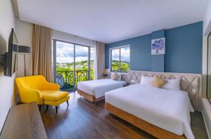 um quarto de hotel com duas camas e uma cadeira amarela em Stillus Boutique Dalat Hotel em Da Lat