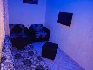 uma sala de estar com duas cadeiras e um sofá em Joclarif Hotel and Suites em Zaria