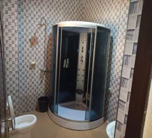 ZariaJoclarif Hotel and Suites的带淋浴、水槽和卫生间的浴室