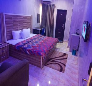 um quarto com uma cama e uma TV em Joclarif Hotel and Suites em Zaria mais 14 fotografias