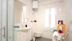 a white bathroom with a toilet and a sink at Holiday house Sunshine in Jelsa +42 photos