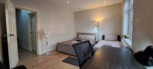 a small living room with a bed and a table at Fenia stay in London
