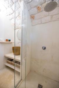 a shower with a glass door in a bathroom at Trullo Cinderella mit Mountainbike & Pool in Martina Franca +29 photos