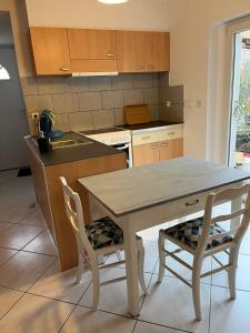 a kitchen with a wooden table and two chairs at studio plein pied in Merxheim