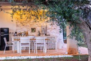 a kitchen with a table and chairs under a tree at Trullo Cinderella mit Mountainbike & Pool in Martina Franca