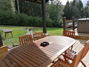 a wooden table with two chairs and aeper at Natur’Lovers - Chalet d’exception - Jacuzzi et hammam en pleine nature in Grendelbruch