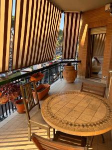 a patio with a table and chairs on a balcony at LA TORTORELLA HOME DI ROMA TALENTI in Rome
