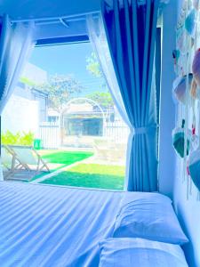 Schlafzimmer mit einem Bett und einem Fenster in der Unterkunft Nguyên Căn Homestay OHANA - Đảo Phú Quý in Cu Lao Thu