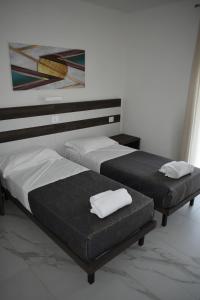 two beds sitting next to each other in a room at Residence La Magnolia - Aparments in Lazise