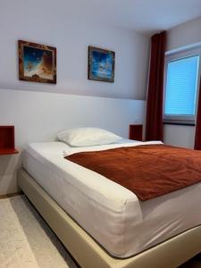 um quarto com uma cama com um cobertor castanho em Baumann Suiten em Ingolstadt