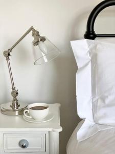 a lamp and a cup of coffee on a bedside table at Luxurious Town House for 4 in Desirable Ludlow - pet friendly in Ludlow