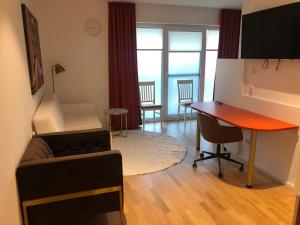 uma sala de estar com uma secretária, um sofá e uma mesa em Baumann Suiten em Ingolstadt