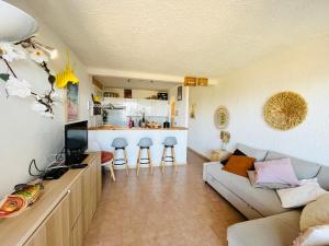 a living room with a couch and a kitchen at Appartement Cocody 3 LUMIO in Lumio