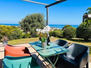 a table and chairs with a view of the ocean at Appartement Cocody 3 LUMIO in Lumio