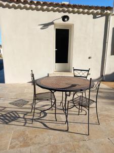 - une table et deux chaises sur la terrasse dans l'établissement Mas Sicard chambre d'hôtes en Camargue, à Arles
