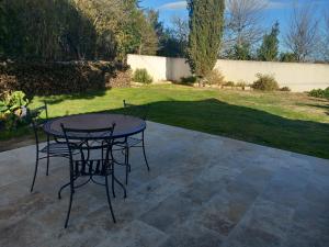 un tavolo e sedie seduti su un patio di Mas Sicard chambre d'hôtes en Camargue a Arles