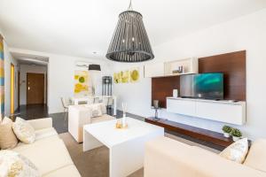 een woonkamer met witte meubels en een flatscreen-tv bij Villas Novochoro - Small Garden in Albufeira