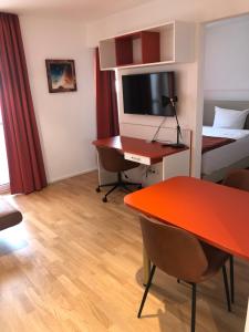um quarto de hotel com uma secretária e uma cama em Baumann Suiten em Ingolstadt