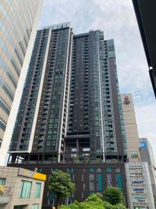 a tall building with many windows in a city at Appartment ASTRO Condo in Pak Kret