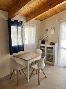 una sala da pranzo con tavolo e sedie e una cucina di B&b AlgueRoof ad Alghero