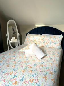 ein Bett mit einem Kissen und einem Spiegel darauf in der Unterkunft westcliff on sea in Southend-on-Sea
