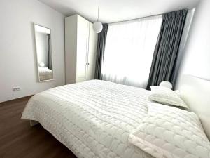 a white bedroom with a large bed and a window at Carolina Residence in Alba Iulia