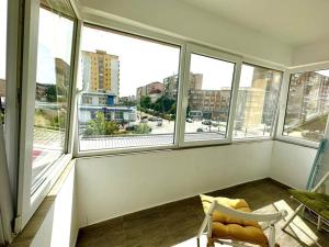 a room with large windows and a chair in a room at Carolina Residence in Alba Iulia