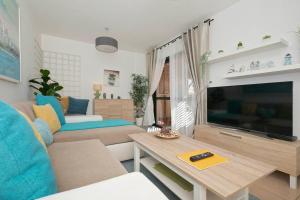 sala de estar con sofá y TV en Lovely Spacious Apartment in San Isidro Tenerife, en San Isidro