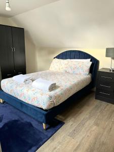 a bedroom with a bed with a black headboard and a dresser at westcliff on sea in Southend-on-Sea