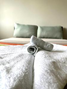 a bed with a white comforter with a bow on it at westcliff on sea in Southend-on-Sea