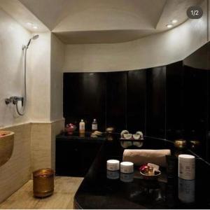 baño con ducha y encimera negra en High standing apartment, en Marrakech